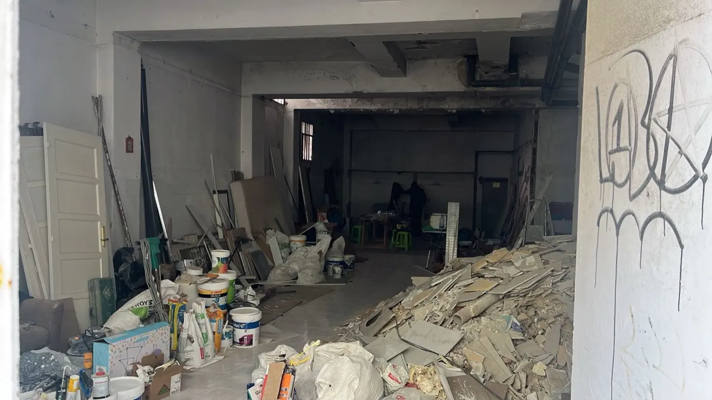 Loja com materiais, baldes de tinta e resíduos acumulados
